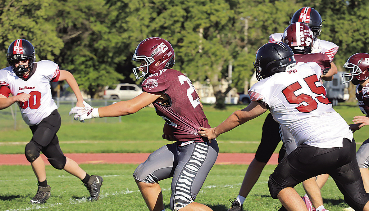 Lewiston’s Brock Janssen (#25) just gets by Pawnee City’s Justin Baehr (#55) on his way to a touchdown in the first half. photo by Paula Jasa, former sports editor