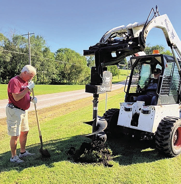 Terry Borcher (L) and Ric Helms (R) use equipment to dig holes for new trees
