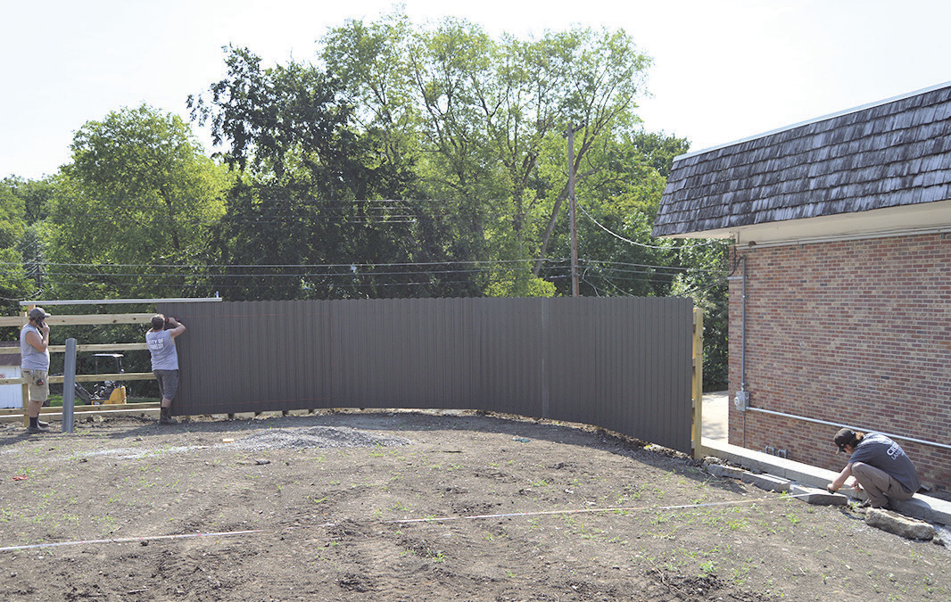 City Crew Foreman Spencer Cumley (left) and crewmember Brandon Holthus (middle) install a fence while a Creative Landscaping employee (right) measures out the width of the park. Photo by Joe Norman