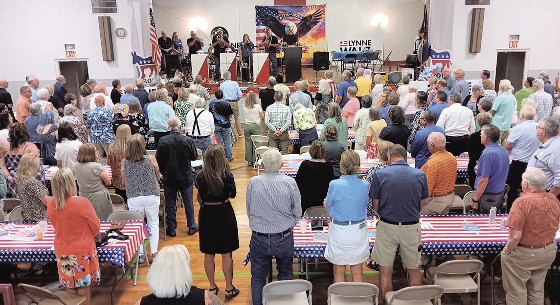 Event attendees stand for the National Anthem