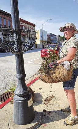 Gail Howard helping to remove flowers from the Chamber planters.