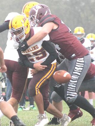 LHS’ Caleb Rule (#14, right) forces a fumble against Sterling early in the game.
