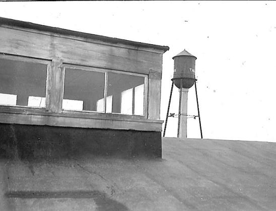 Above: When the Table Rock Volunteer Fire Department was formed in 1899, plays were held in the opera house to raise money for it. In this 1941 picture by Arvid Blecha you see the skylight of the opera house with the original water tower of 1922 beyond. On the cross brace of the water tower, difficult to see but there, the siren and the old fire bell. The siren was later moved to the old fire hall, and the bell placed at ground level in its present location.