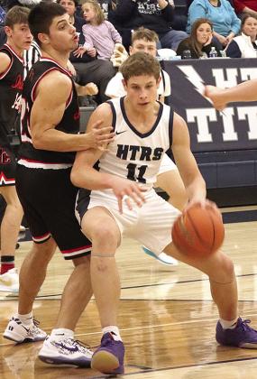 HTRS’ Emmett Glathar (#11) drives the lane against P.C.’s Anthony Kling (left) in Tuesday night’s game. Paula Jasa/Republican