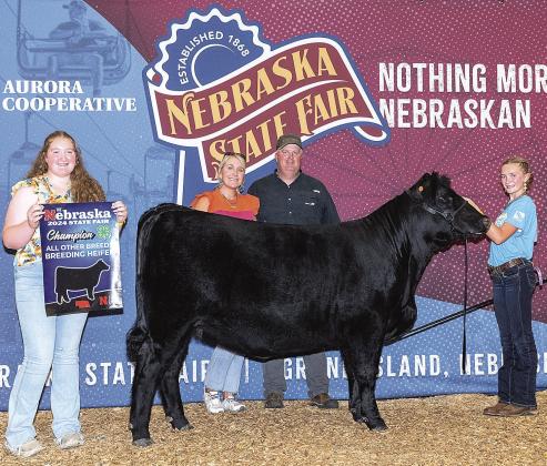 Sisters Adelyn (L) and Aubrey (R) with their parents Whitney and Andrew Sisco posed with their Champion Breeding Heifer