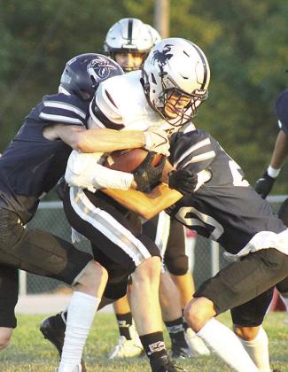 HTRS’ Brogan Dunlap (left) and Axton Wamsley (#20, right) bring down an Elmwood-Murdock runner. Paula Jasa/Republican