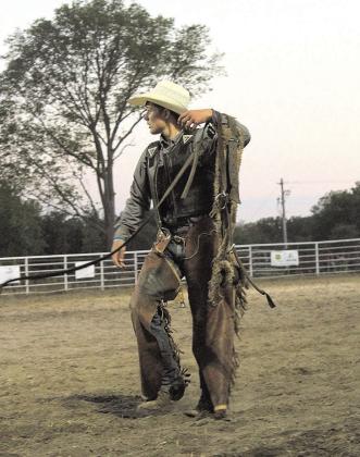 A saddle bronc rider looks to the judges as his score is announced