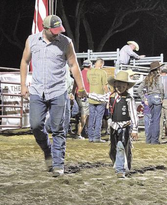 A mutton buster proudly exits the arena after a successful ride