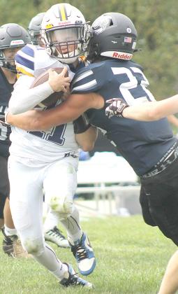HTRS’ Hunter Bohling (#22, right) makes a textbook tackle on Omaha B-T’s quarterback and stuffs him at the line of scrimmage in Saturday morning’s game. Bohling had 9 tackles and 1 sack in the game. Paula