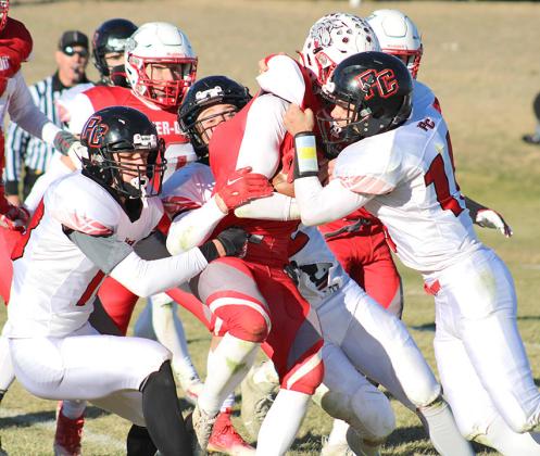 P.C.’s Hunter Johnson (left), Andy Maloley (center) and Anthony Kling (right) sandwich a Potter-Dix player in an Indian gang tackle on Friday afternoon. photo courtesy of Jamie Maloley