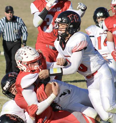 P.C.’s Anthony Kling (#16, right) helps make a tackle against Potter-Dix on Friday. Kling had 10 tackles and a fumble recovery in the game. photo courtesy of Jamie Maloley