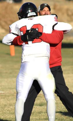 Pawnee City Asst. Coach Shane Maloley gives son Andy Maloley a hug after the Indians upset the Potter-Dix Coyotes 62-47 on Friday. photo courtesy of Jamie Maloley