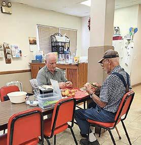 Located in Table Rock, the office of Blue Rivers Area Agency on Aging serving Pawnee County welcomes everyone who would like a home cooked meal. The centers’ cook is Sput Turnbull and anyone who has enjoyed a meal at the center is bound to return. Sputs’granddaughter, Madison Plager, left, volunteers at the center. Paul Nimmich and Ed DeJonge, both of Pawnee City, are put to work on KP duty peeling potatoes.