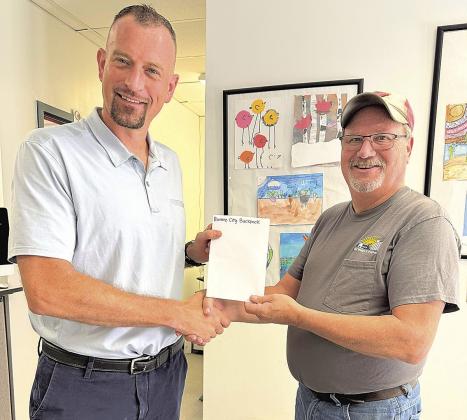 Suberintendent Rottinghaus left accepting donation from Jeff Wehrbein right.