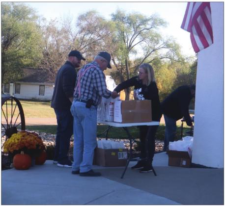 Farmers got a present from First Bank of Nebraska in Burchard Thursday afternoon. They received a meal to go with other goodies as a way of saying thanks for all their efforts during harvest. The event called Harvest Bonanza was co-sponsored by KUTT. Pictured is Ron Leitschuck getting goodies from the bank’s Linda deKoning. Ray Kappel/Republican