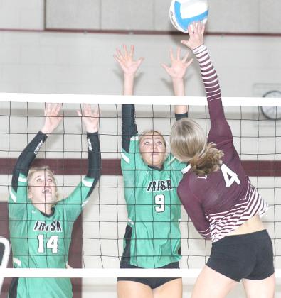 LHS’ Emma deKoning (#4, right) skies for a tip over two FCSH blockers. Paula Jasa/Republican