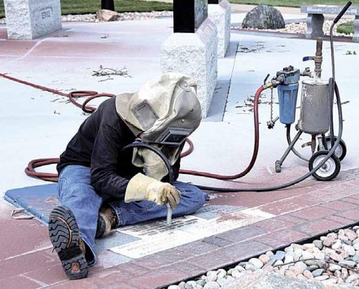 Bill Kruger of River Valley Memorials worked on the Veterans Memorial in Tecumseh recently. Ray Kappel/Republican