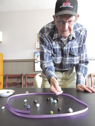 Above: Will’s nephew Art Alderman had played marbles a few times. Asked to pose, he chose to play. That white blur closest to the camera was Art’s shooter crashing another marble out of the ring. If he was playing for “keepsies,” he could get to keep that other marble.