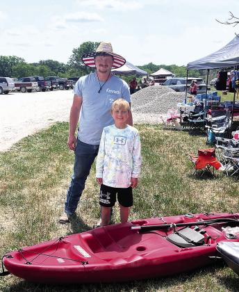 Kenneth Klepper stands with Alex Graf, winning his new kayak.