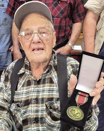 Kenneth Eichenberger receives his medal surrounded by his friends Photo by Sput Turnbull