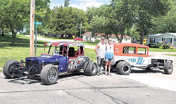 Paula and Kevin pose with their race cars.