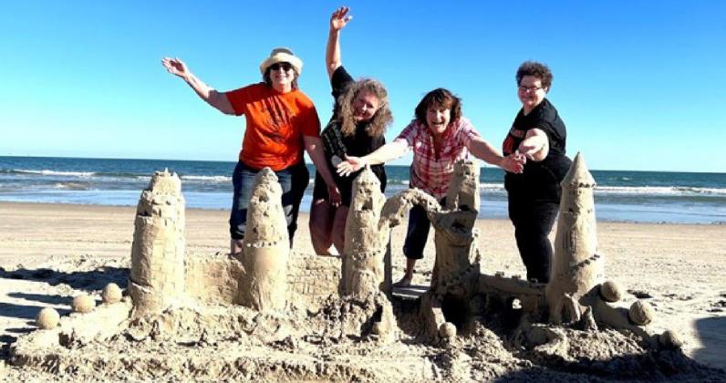 Sisters Sandy Cerra, Suzanne Ellis, Sharla Sitzman, and Sherry Winkinhofer with their 2022 sandcastle
