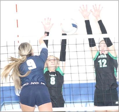 HTRS’ Avery Dierberger (#9, left) powers a spike past two FCSH defenders in the Class B Mudecas Championship game on Thursday. Paula Jasa/Republican