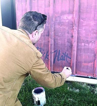 Artist Nick Flatt signs his work in Steinauer, Nebraska photos provided by Suzanne Borcher