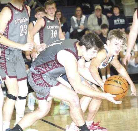 LHS’ Brady Bledsaw (#11, left) battles HTRS’ Brennen Vaughan (#2, right) for a loose ball during the Tigers vs. Titans game last Tuesday. Lewiston won 34-32. Paula Jasa/Republican