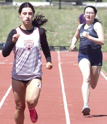 LHS’ Savannah Cutshall (left) finishes just ahead of HTRS’ Colby Hedden (right) in the girls’ 200 M. prelims. Paula Jasa/Republican