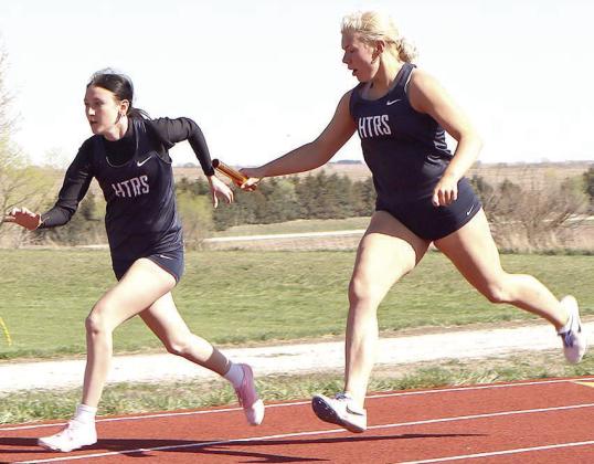 HTRS’ Elie Bstandig (right) hands off to teammate Harlee Hardesty (left) for the second leg of the girls’ 400 M. relay event. Paula Jasa/Republican