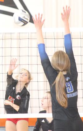 Paula Jasa/Republican P.C.’s Madison Fender (#5, left) launches a spike past a Nebraska City Lourdes defender in the Pioneer Conference 3rd place game on Saturday.