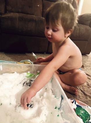 Charlie Neemann, 3, plays with his Hot Wheels in snow his mother, Michelle Wenzl, brought inside. These little cars are a lot easier to drive out of a snow drift.
