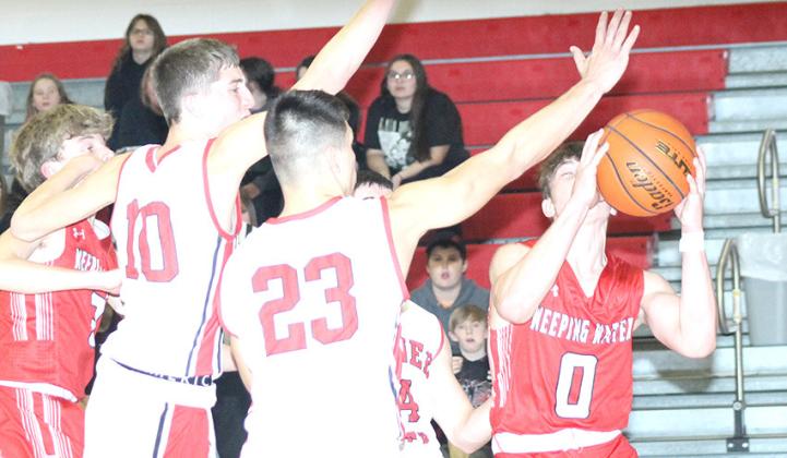 P.C.’s Drew Menninga (#20) and Anthony Kling (#23, left) prevent a Weeping Water player from driving the baseline in Tuesday night’s game before the Holiday break. Paula Jasa/Republican