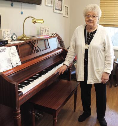 Shirley Huls stands by the piano in the Pawnee City Assisted Living Facility. Huls learned to play the piano as a little girl in the 30s and 40s and still enjoys listening to classical music as an adult.