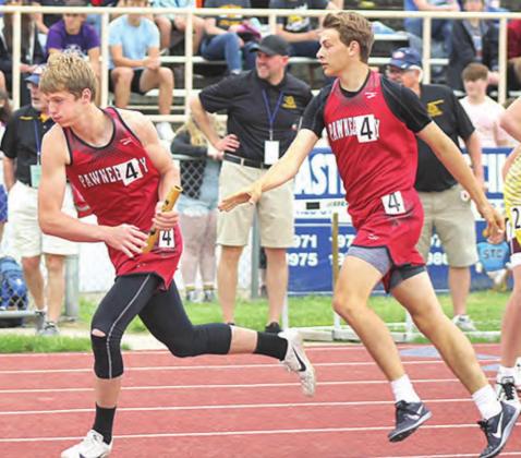 P.C.’s Kyle Gyhra takes the baton from Kaden Lang in the boys’ 1600 M. Relay event on Thursday. Paula Jasa/Republican