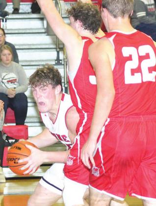 P.C.’s Simon Osborne (left) goes Frankfort players on the baseline. up against several Paula Jasa/Republican