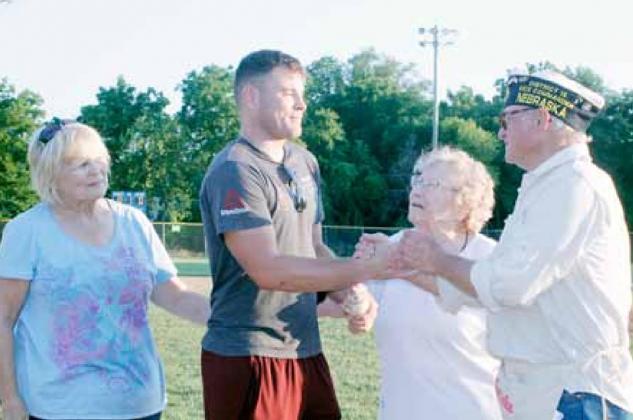 Dan Kwiatkowski, second from left, was surprised to be recognized with a game ball signed by the Tecumseh Legion Juniors and Seniors baseball teams. His mother, Jean Kwiatkowski, left, and grandmother, Verna Mae Richardson, right, both of Pawnee City, joined Dan for the presentation of the autographed baseball by Tom Rother, right, American Legion Post #2 baseball program coordinator.