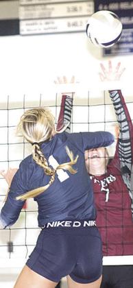 HTRS’ Laramie Glathar (#1, left) powers a spike past LHS’ DeLanye Currie (#7, right) last Tuesday. Paula Jasa/Republican
