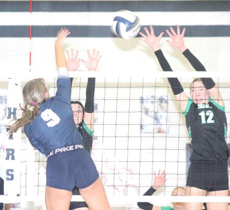 HTRS’ Avery Dierberger (#9, left) splits two FCSH defenders in the D2-1 subdistrict final match. Dierberger landed 20 kills against the Irish in the four set victory. Paula Jasa/Republican