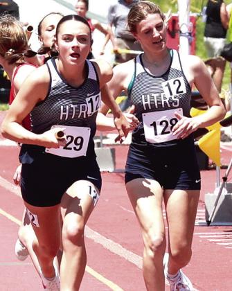 HTRS Girls’ 3200 M. Relay team of Grayson Sherman (photo left) and Lillian Bowen (photo right) taking the baton from Addi Bittner (far right) ran the first race of the 2024 Class D State Track Meet. Photos courtesy of Lorrie Novak