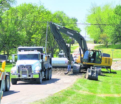 Workers install a wider tube to prepare to expand the fairgrounds road to a two lane road per the street plan.