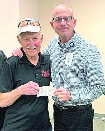Dr. Rick Jackson, retired, hands a check to John Werner which pays off the loan for the new ambulance.