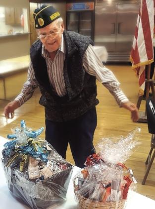 Kenny Eichenberger, oldest World War II vet in Pawnee County, tries to choose between two door prizes. He