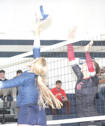 HTRS’ Laramie Glathar (left) tips the ball over a Meridian player in Thursday night’s match. Glathar had 45 set assists, 1 kill and 1 block at the net. Paula Jasa/Republican