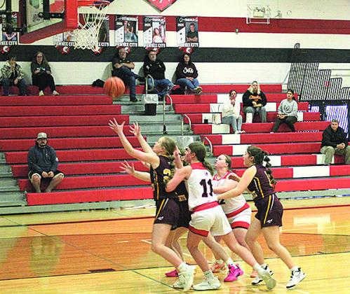 Members of the Junior Varsity Pawnee City Indians and Sterling Jets teams reach for the ball as it falls from the hoop