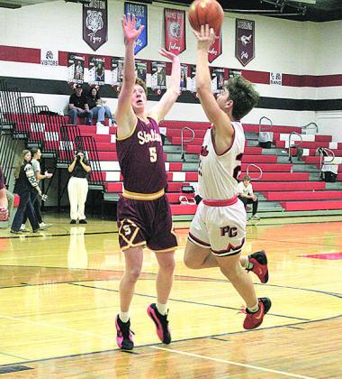 Pawnee City Senior Tyler Tegtmeier shoots for a score as Sterling Junior Owen Uher attempts to block