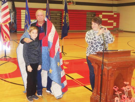 Ray Kappel/Republican Veteran Larry Sinagoga with his grandson JJ Maynard and his mom, Beka at the Pawnee City Schools Veterans Day program. JJ made a Quilt of Valor for his grandpa.