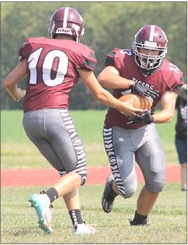 LHS’ Everett Bohling (#10, left) hands off to Brady Bledsaw (#13, right) for a good gain over the left side. Bledsaw had 5 carries for 76 yards and 2 TD’s in the 81-41 win over St. Edward. Paula Jasa/Republican