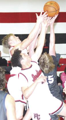 P.C.’s Darius Andersen (center) and Trey Marteney (center left) go up against HTRS’ Colt McClarnen (#15, right) for a rebound. Paula Jasa/Republican